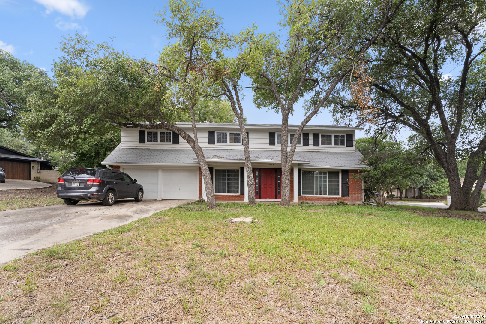 a view of a house with a patio and a yard