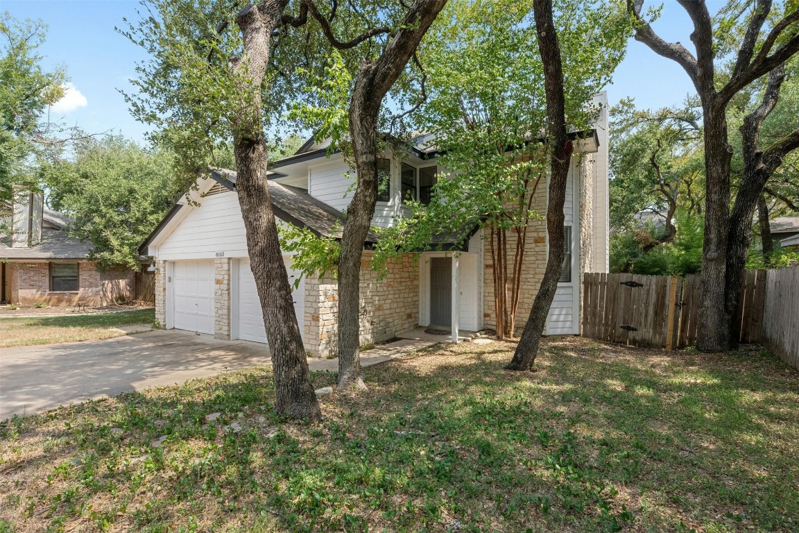 Culdesac Lot with towering oak trees, stacked stone and recent Hardi siding.