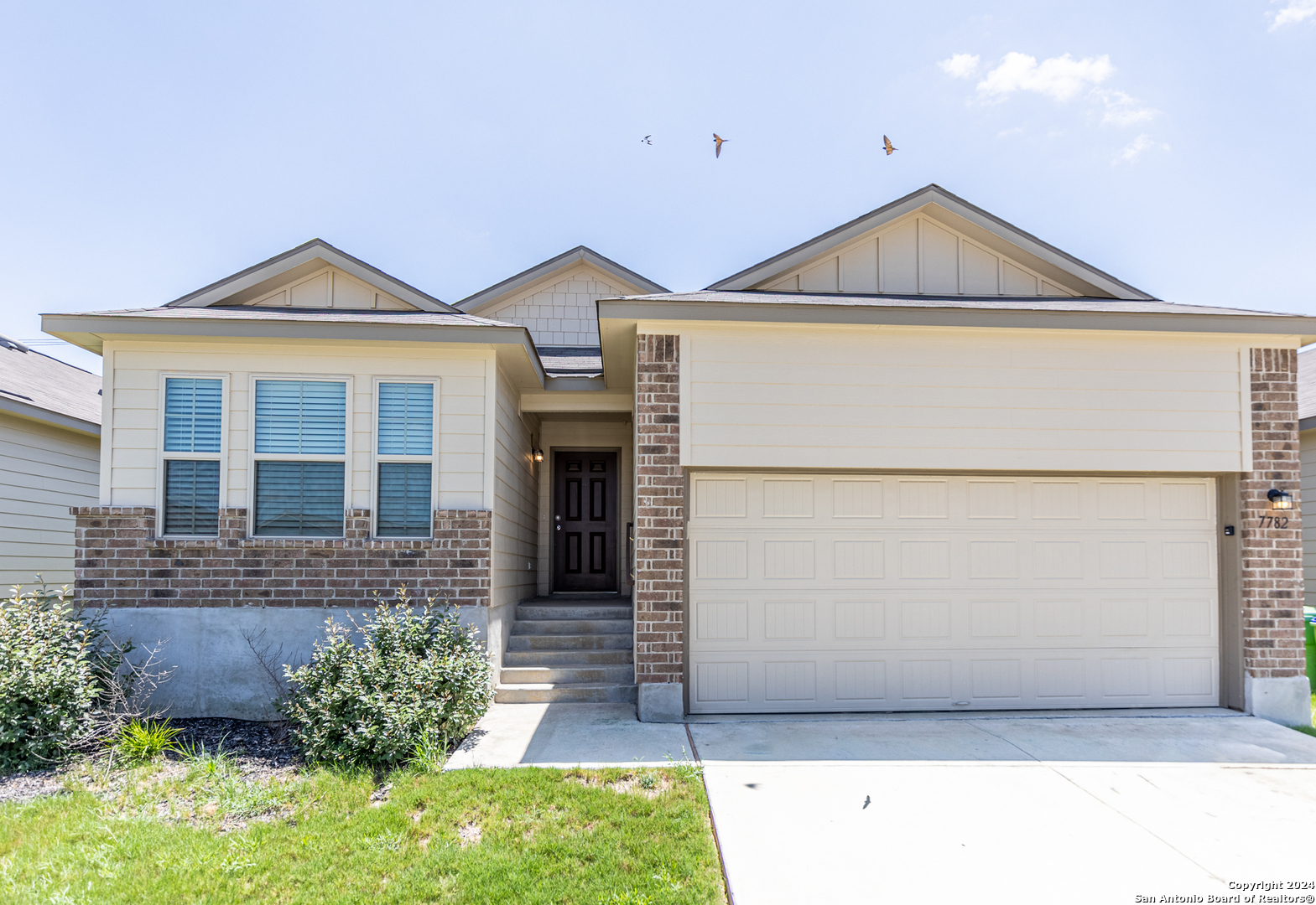 a front view of a house with a yard and garage