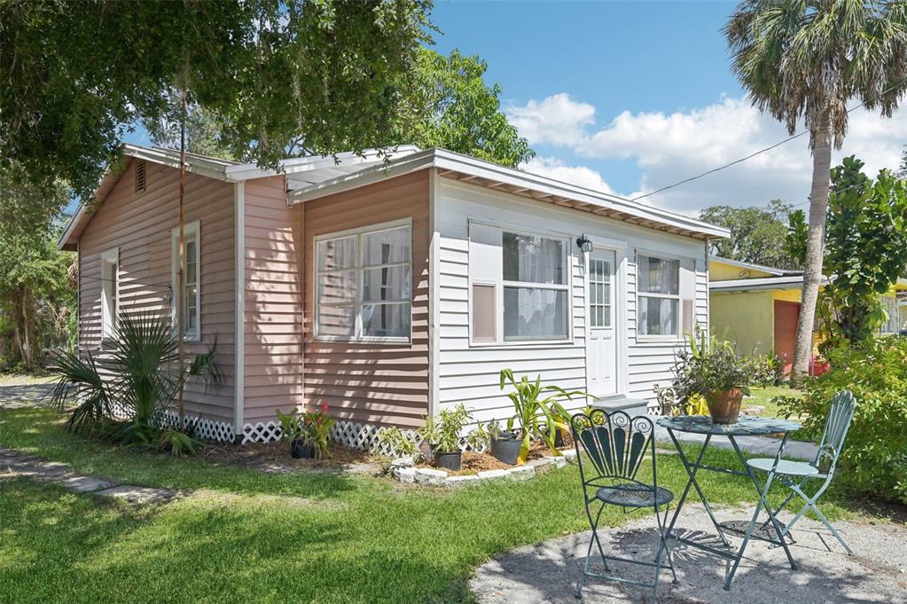 a front view of a house with a garden and chairs