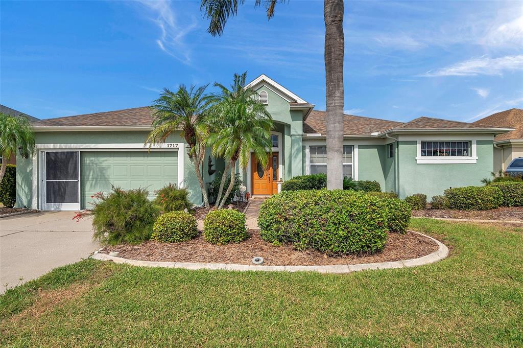 front view of house with a yard and potted plants