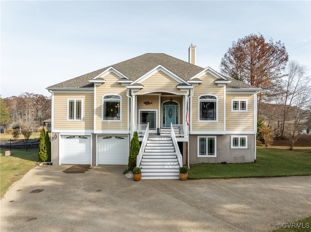 Bi-level home with a front yard, a garage, and cov