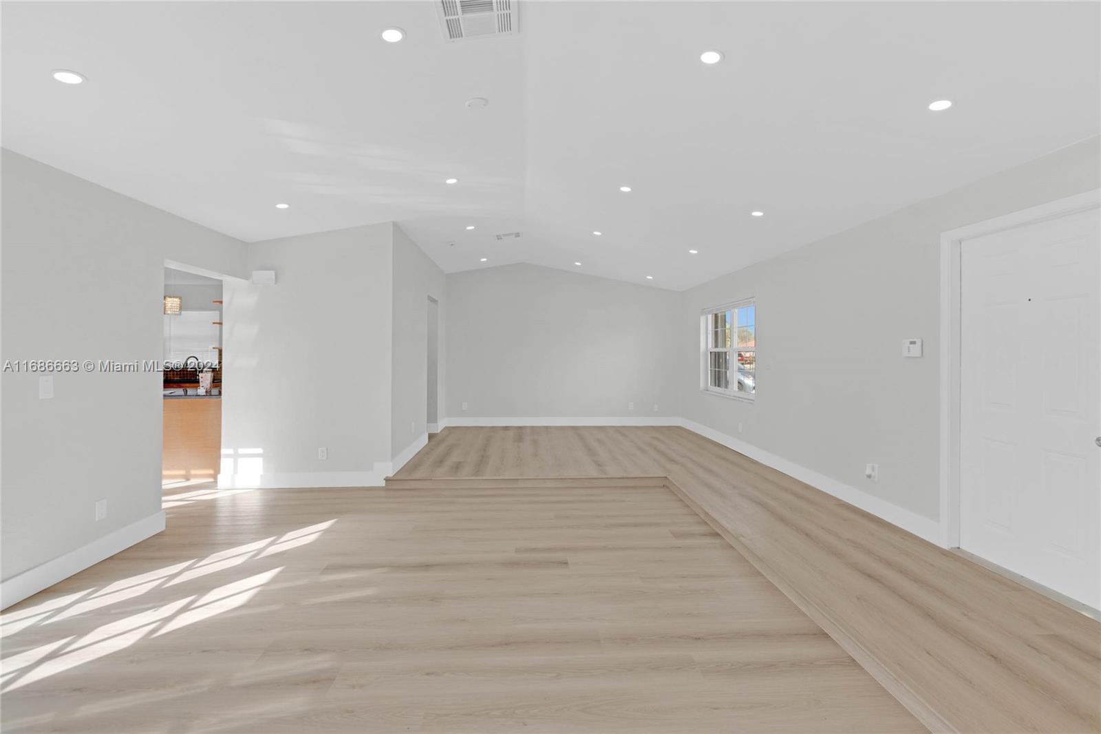 a view of empty room with wooden floor