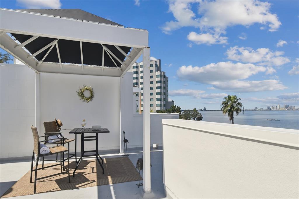 a roof deck with table and chairs