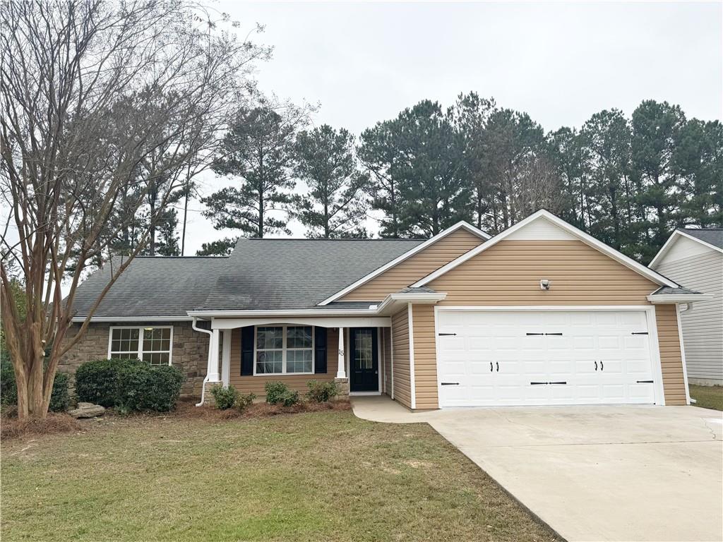 a front view of a house with a garden and trees