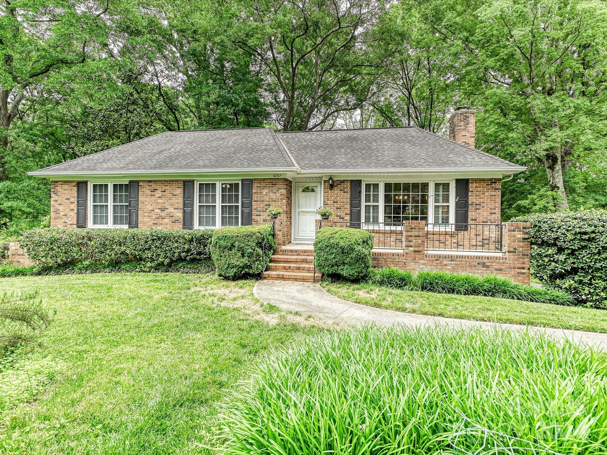 a view of a house with a yard and potted plants