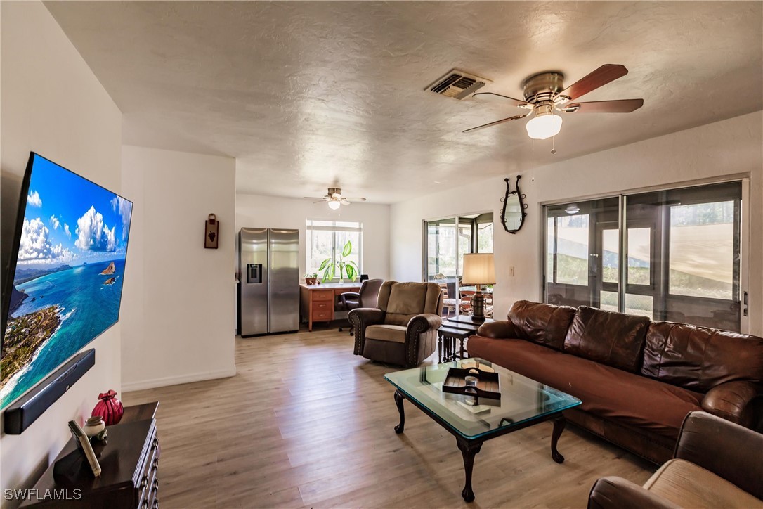 a living room with furniture and a flat screen tv with wooden floor