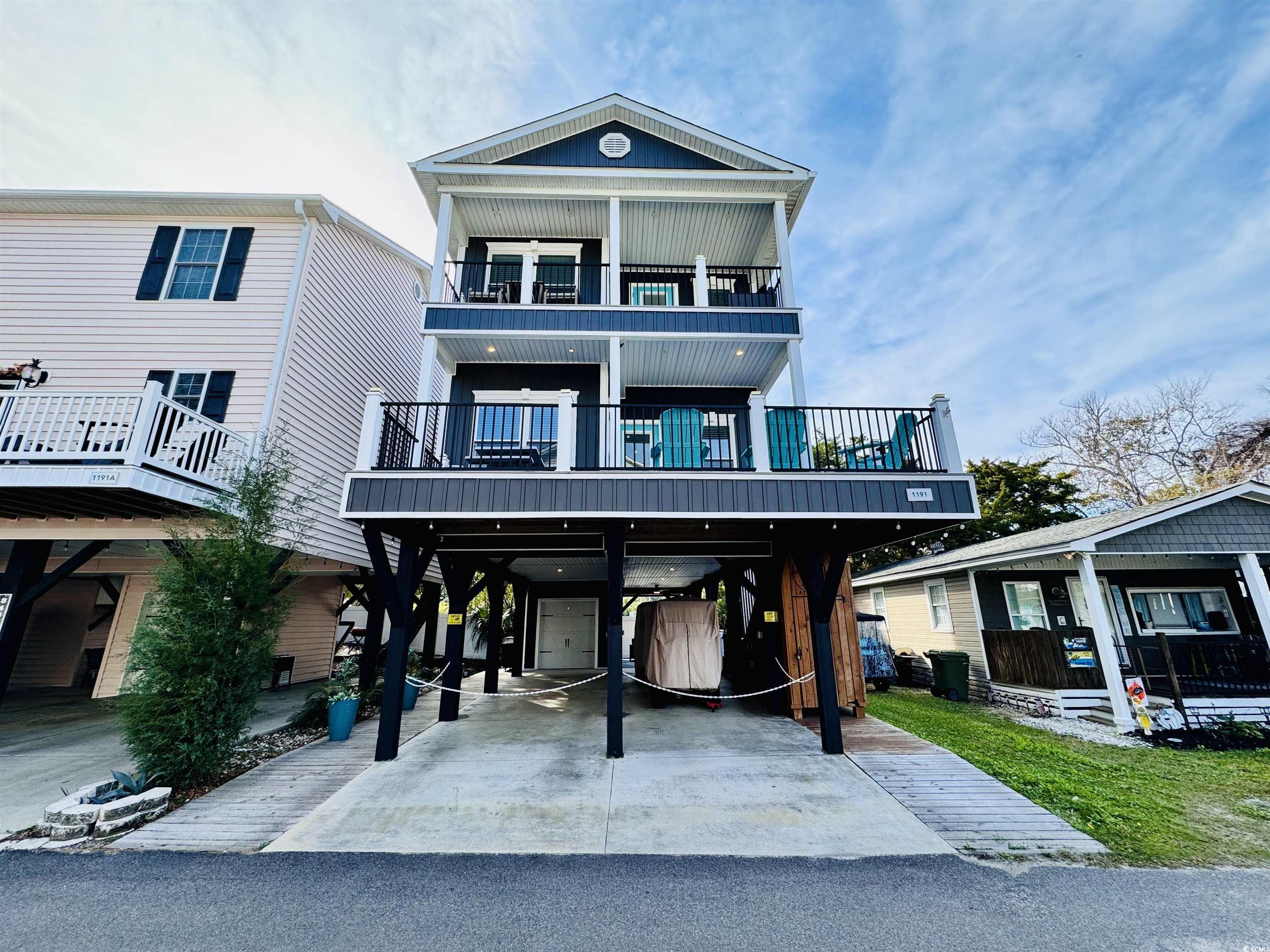 Coastal inspired home with a balcony and a carport