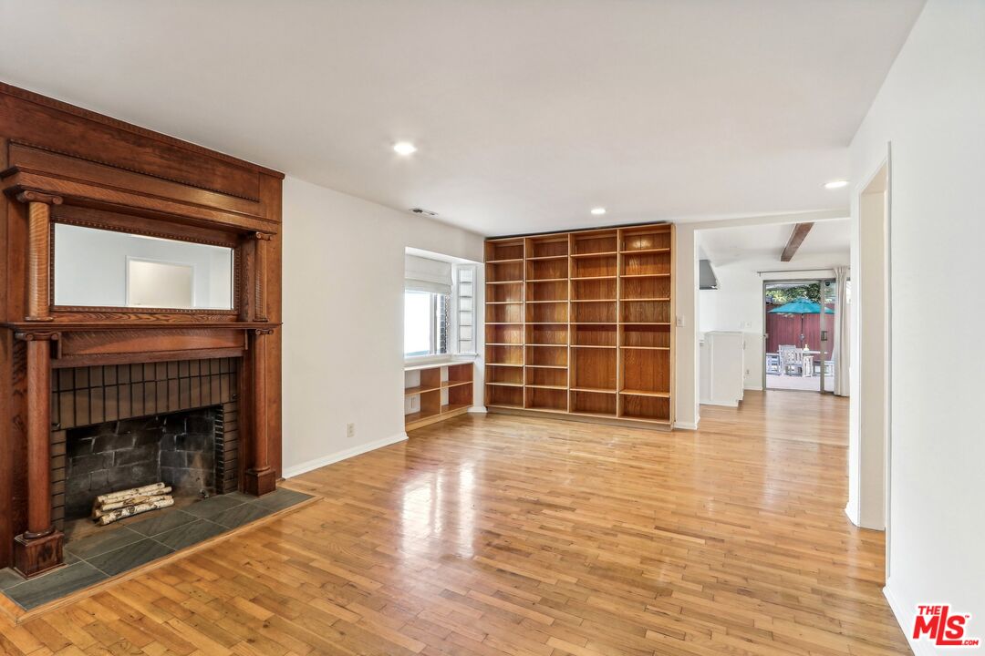 a view of an empty room with a fireplace and a window