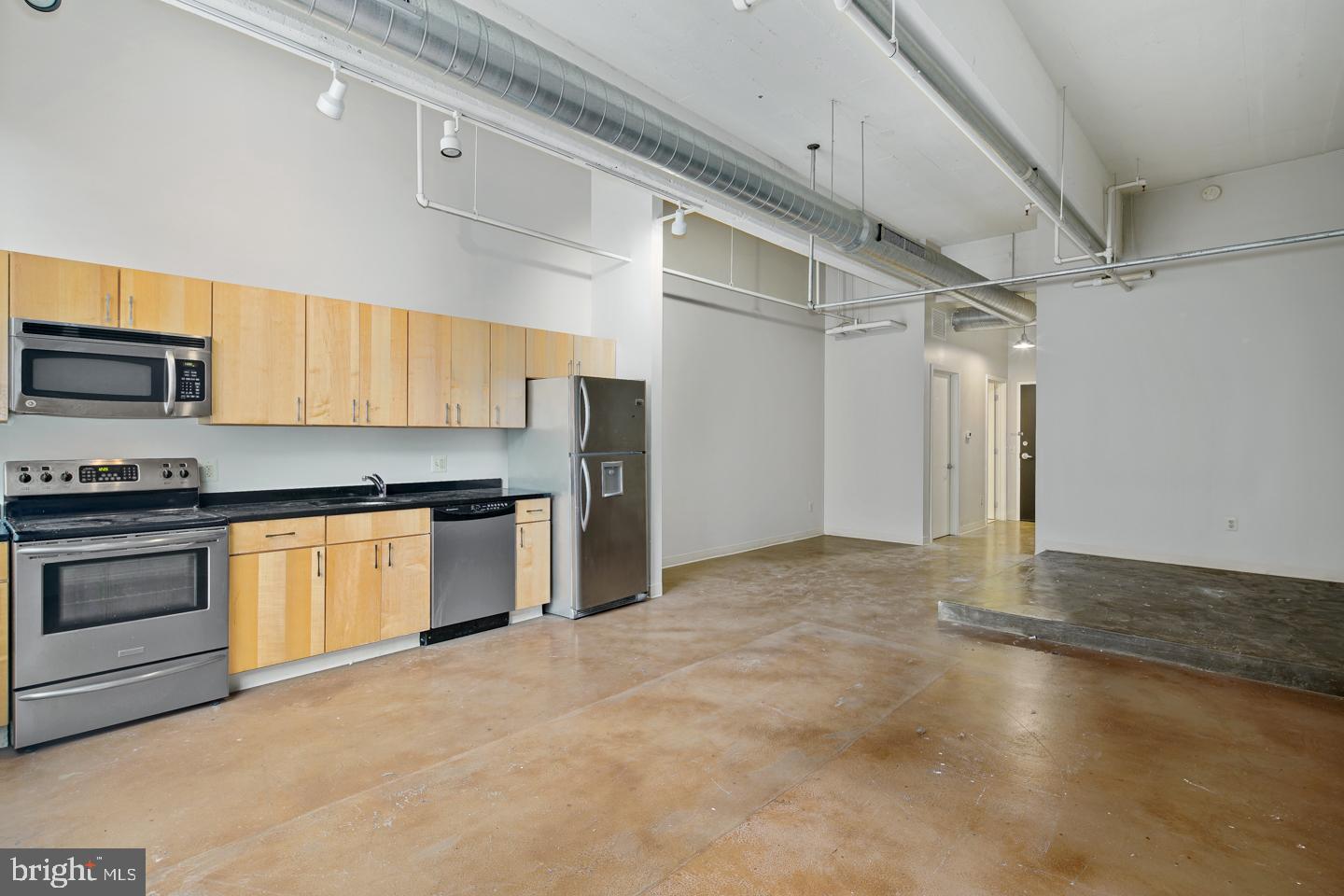 a kitchen with granite countertop a stove a sink and a refrigerator