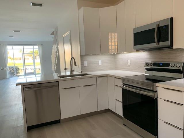 a kitchen with stainless steel appliances granite countertop a stove microwave and sink