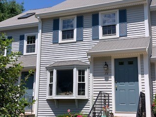 a view of a house with a door and a tree