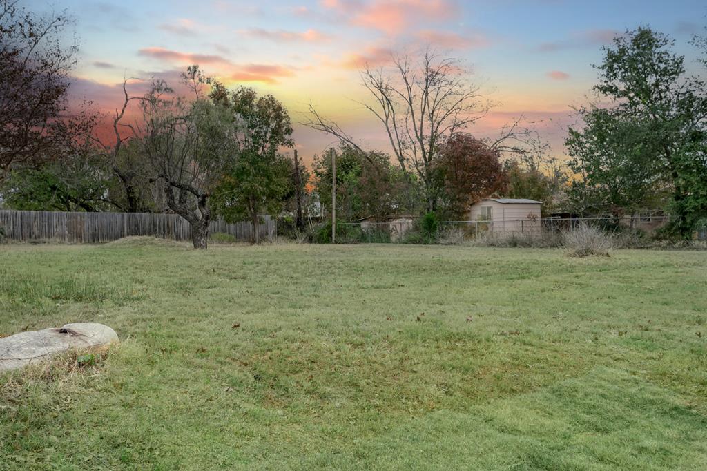 a view of a field with trees in the background