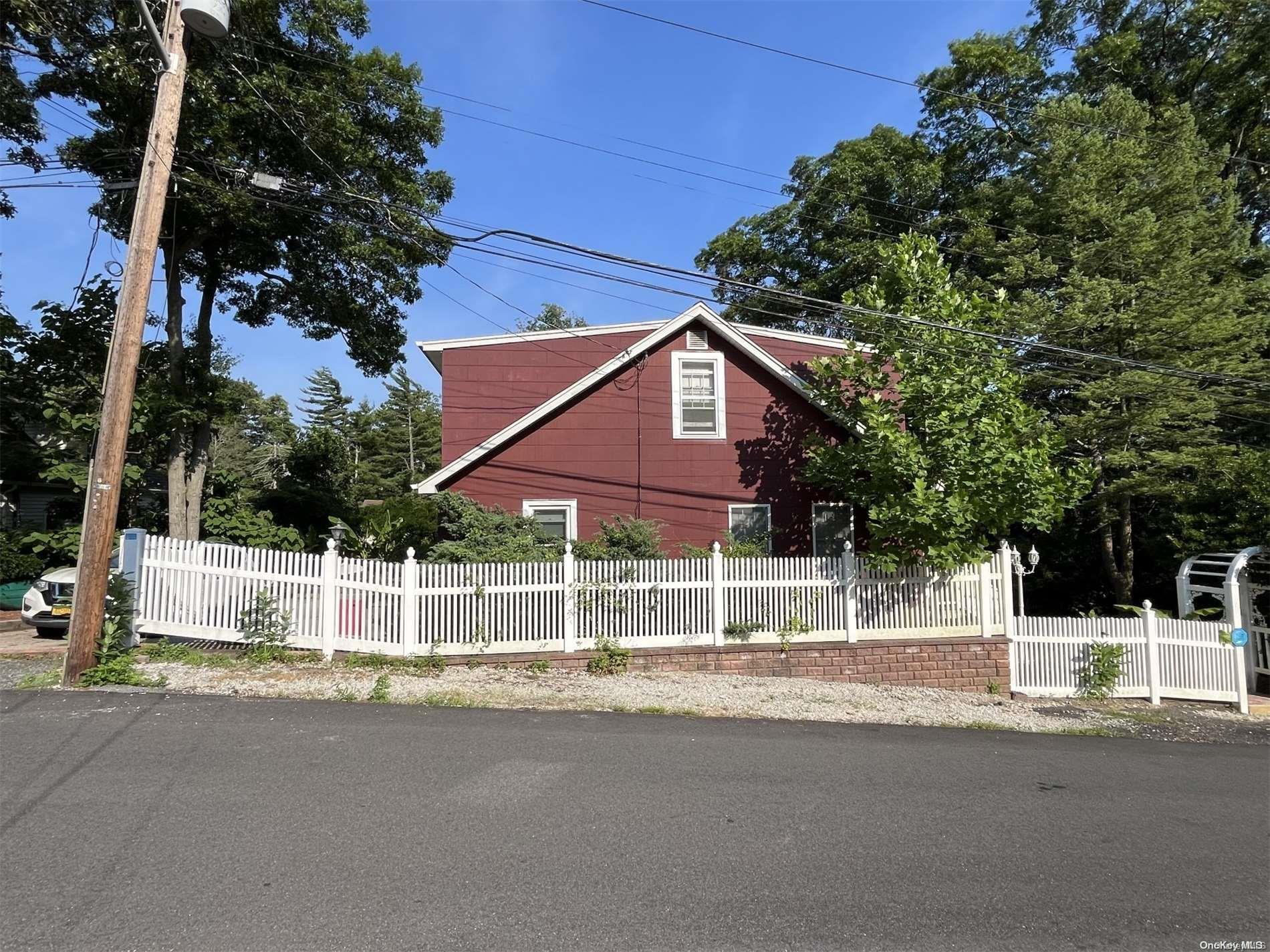 a view of a house with a yard and large trees