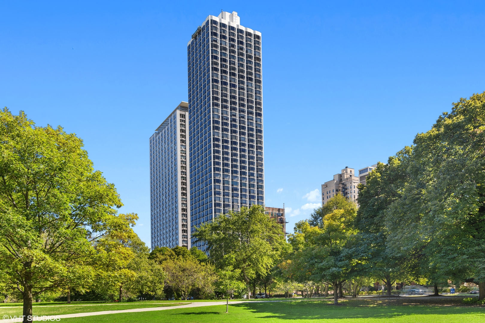 a view of a tall building next to a yard