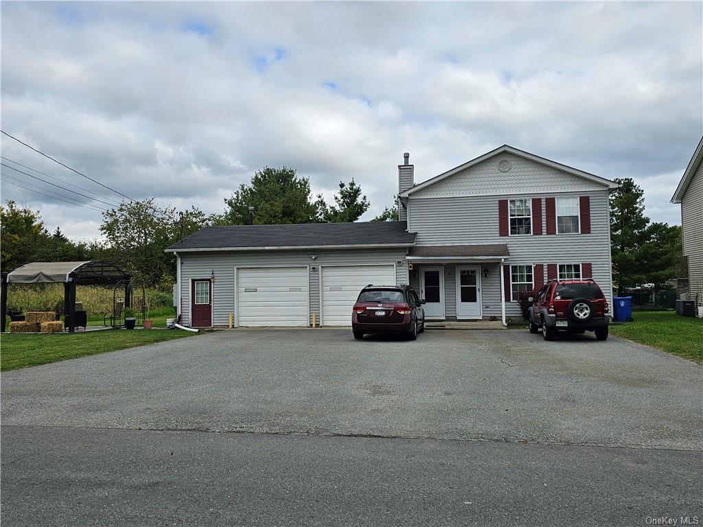 View of front of property featuring a front lawn and a garage