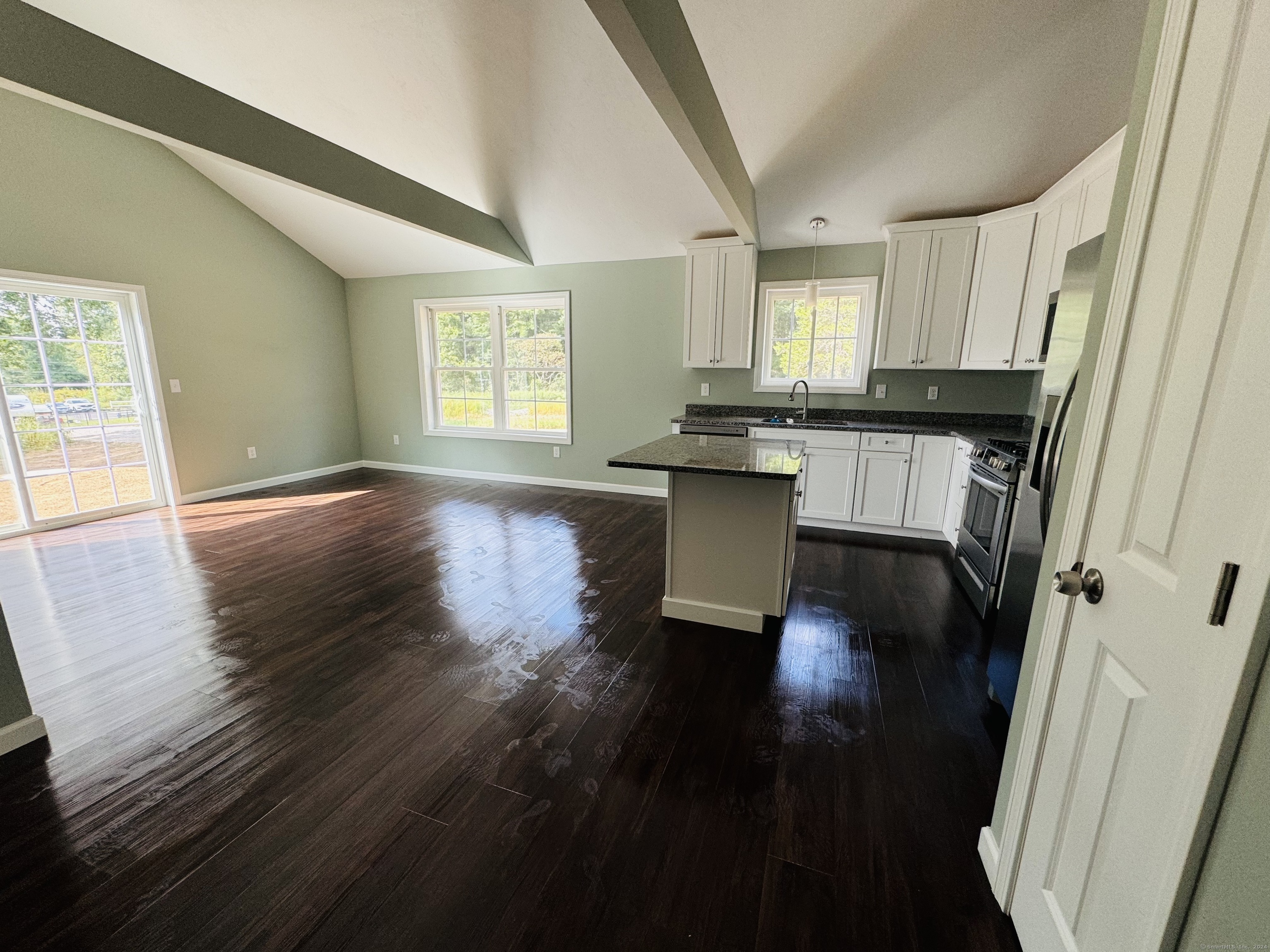 a view of kitchen and hall with wooden floor