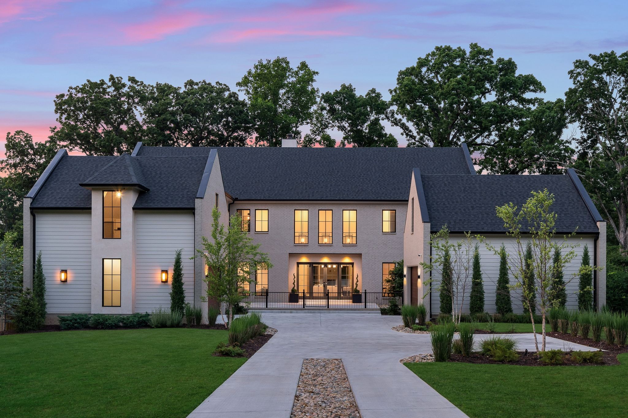 a front view of a house with a yard and trees