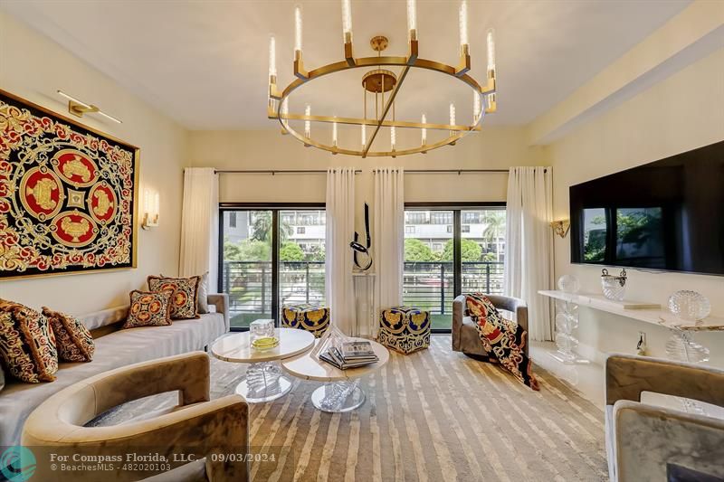 a living room with furniture a flat screen tv and a large window