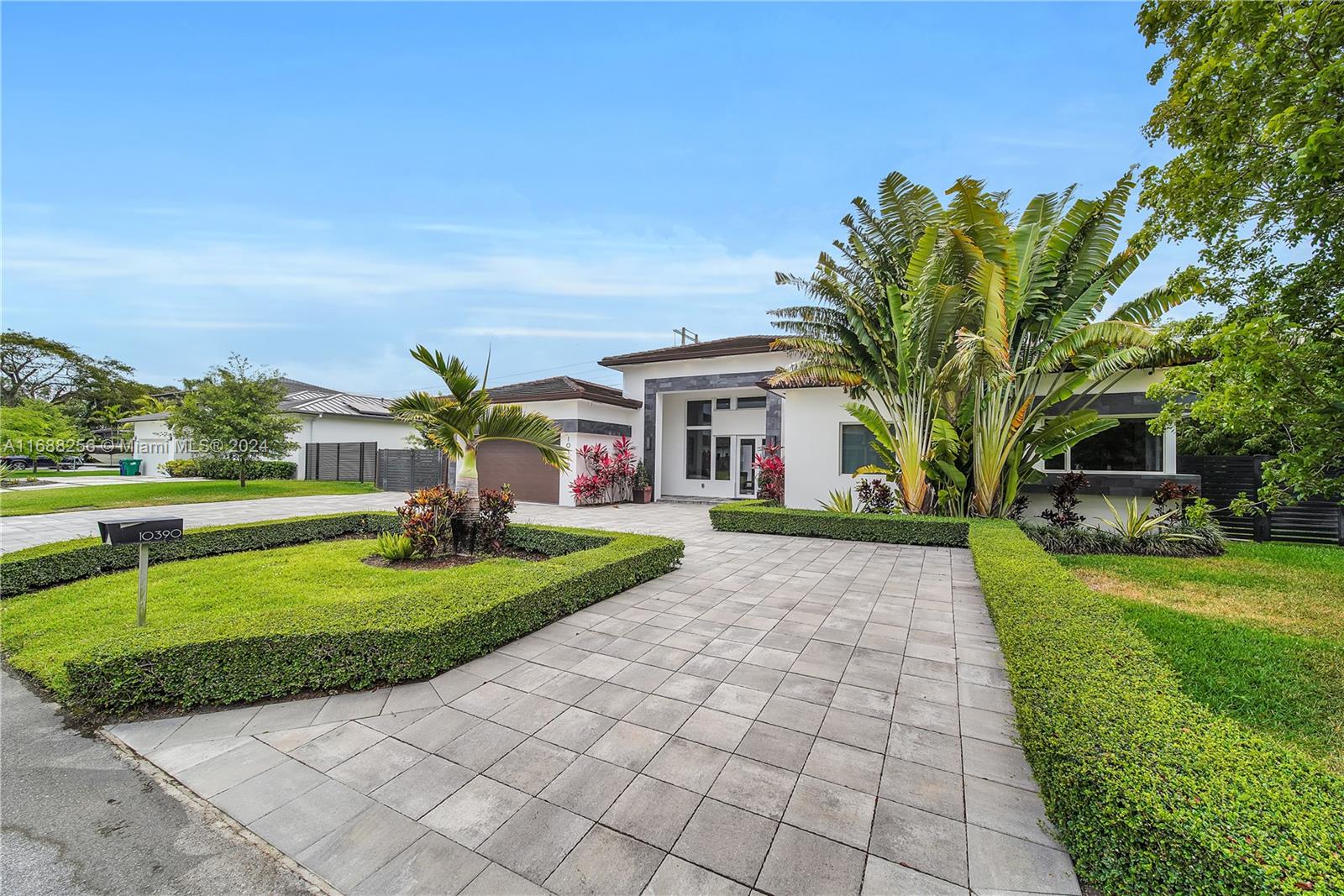 a front view of a house with a yard and trees