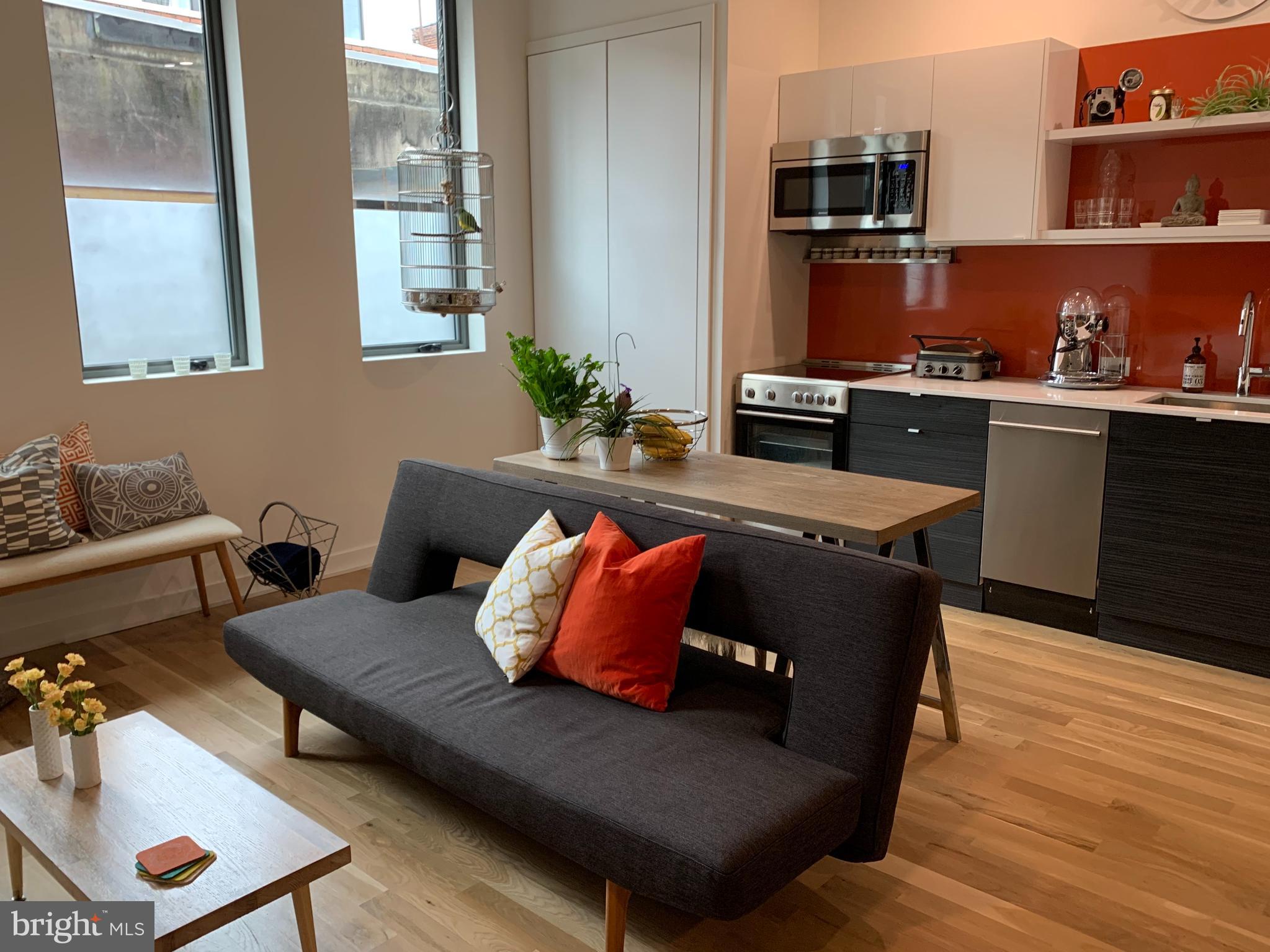 a living room with furniture and wooden floor