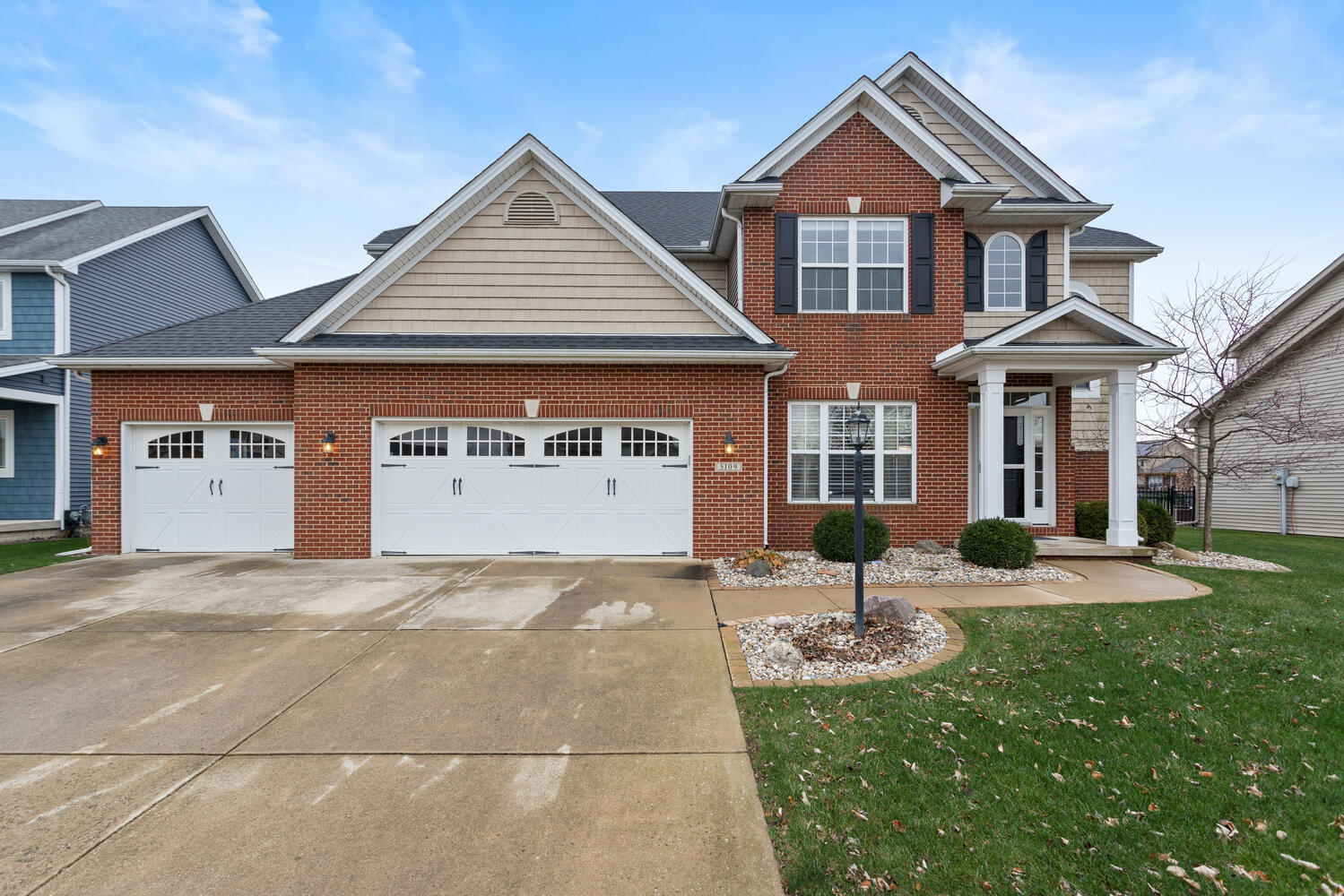 a front view of a house with yard and parking