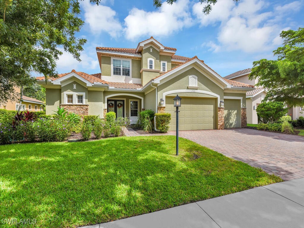 a front view of a house with a yard and trees