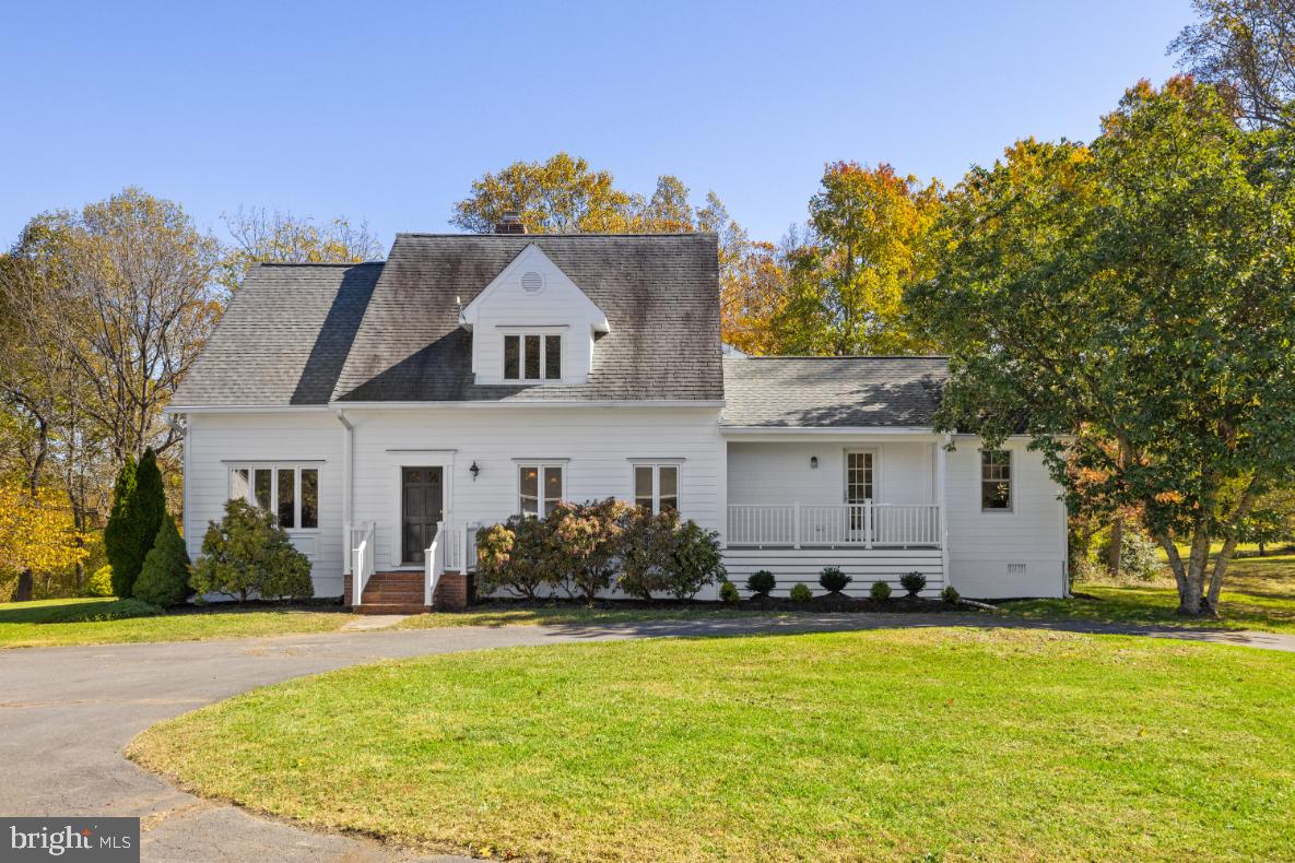 a front view of house with yard and trees in the background