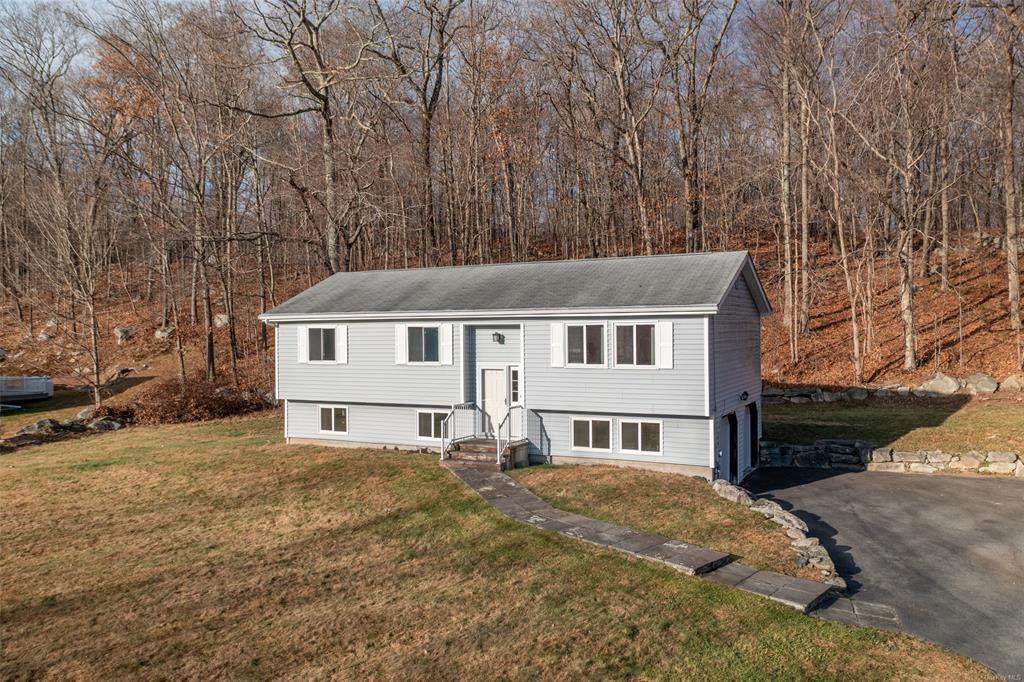 a front view of a house with a yard covered with snow in front of house