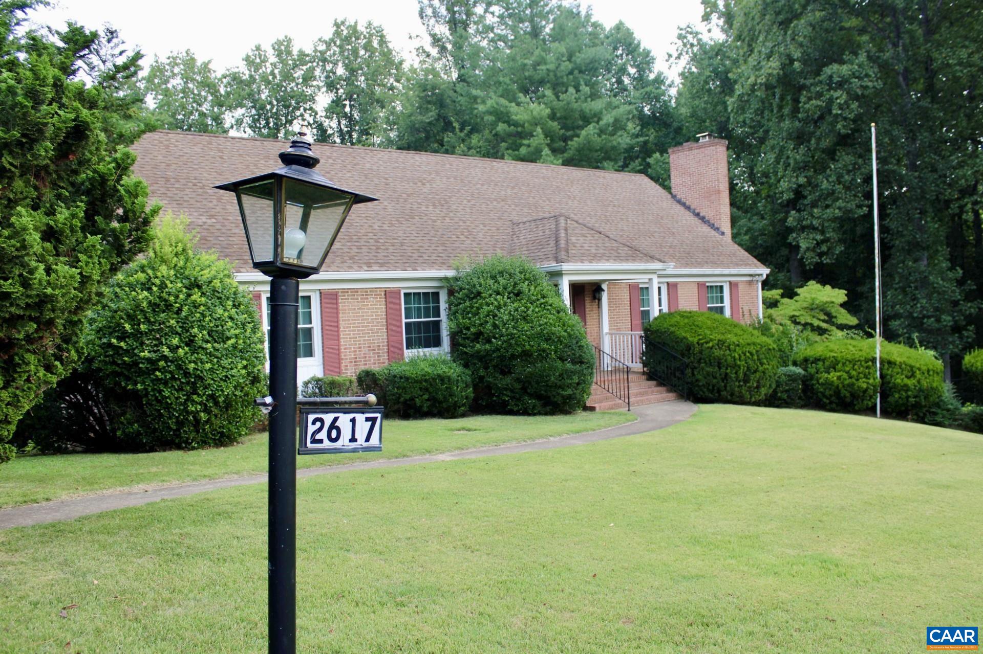 a front view of a house with a yard and tree