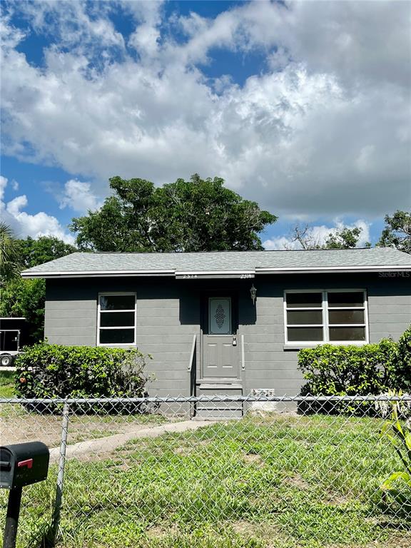 a front view of house with yard and trees around