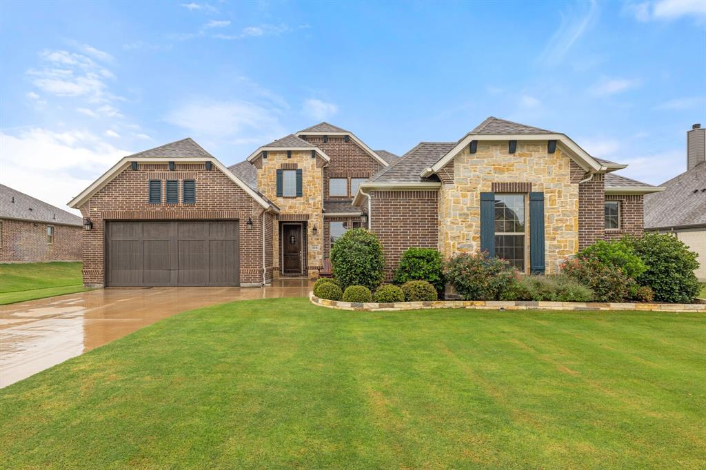 View of front of home with a garage and a front lawn