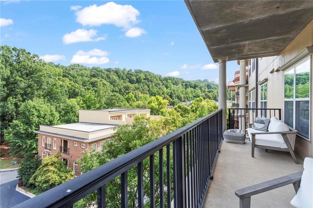 a balcony with wooden floor and outdoor seating