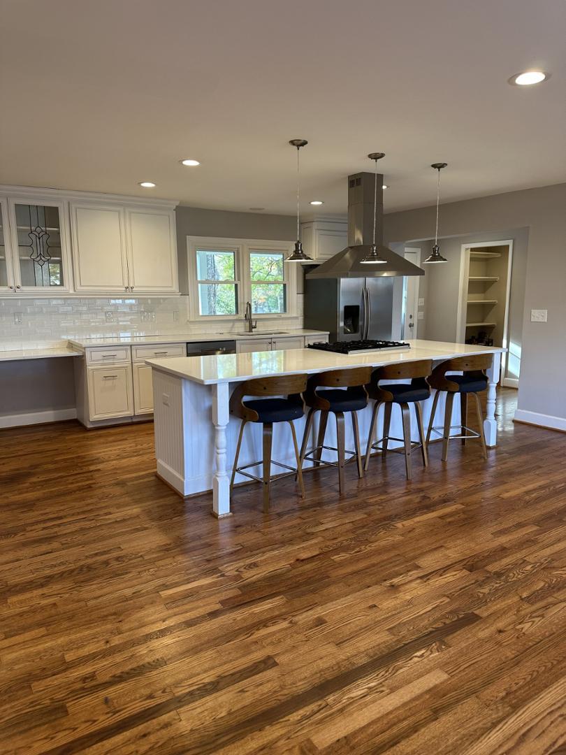 a kitchen with stainless steel appliances granite countertop a dining table chairs and granite counter tops