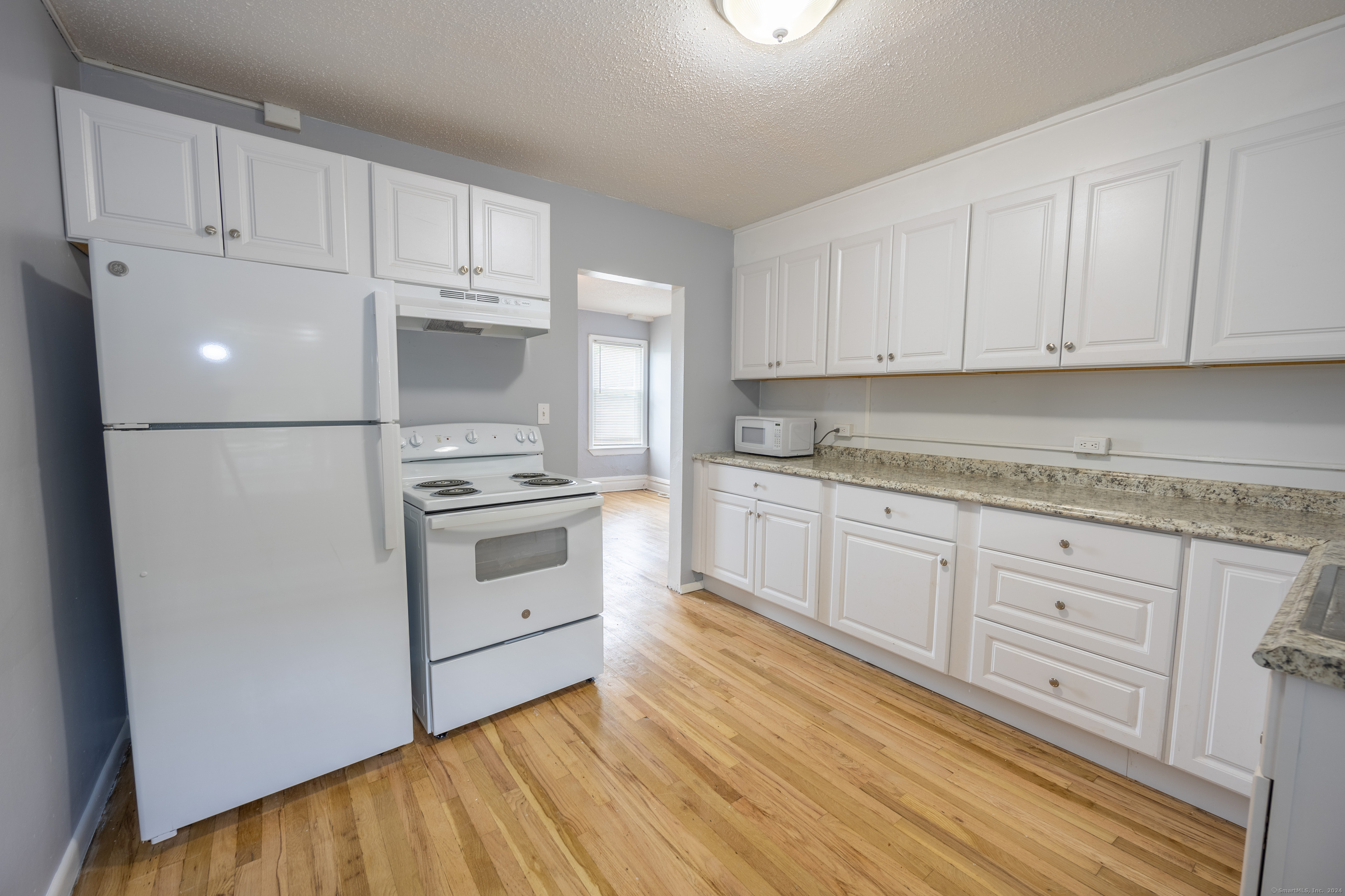 a kitchen with white cabinets and white appliances