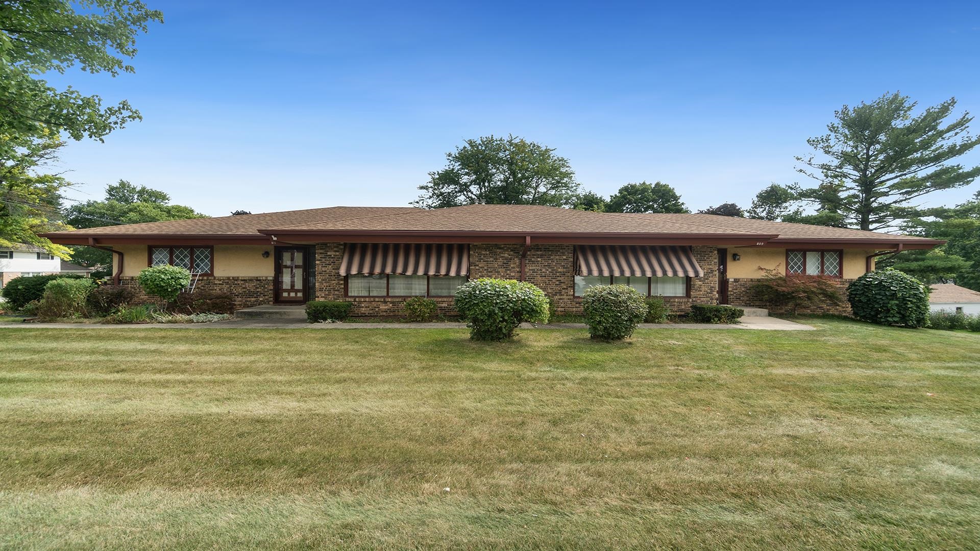 a front view of a house with a garden