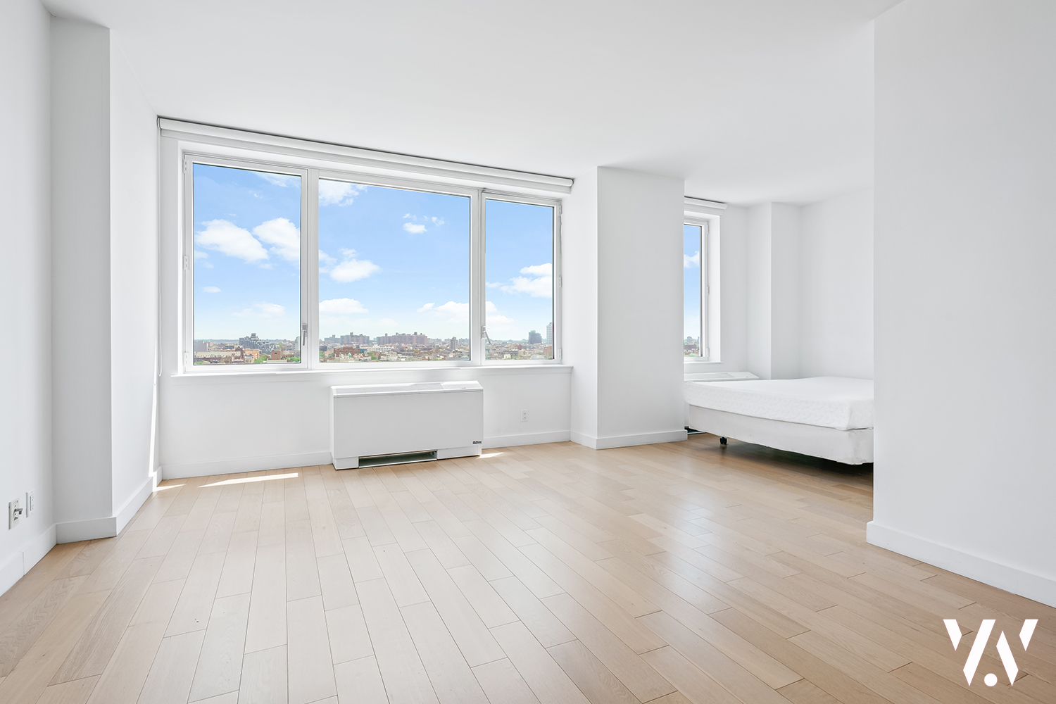 a view of a big room with wooden floor and windows