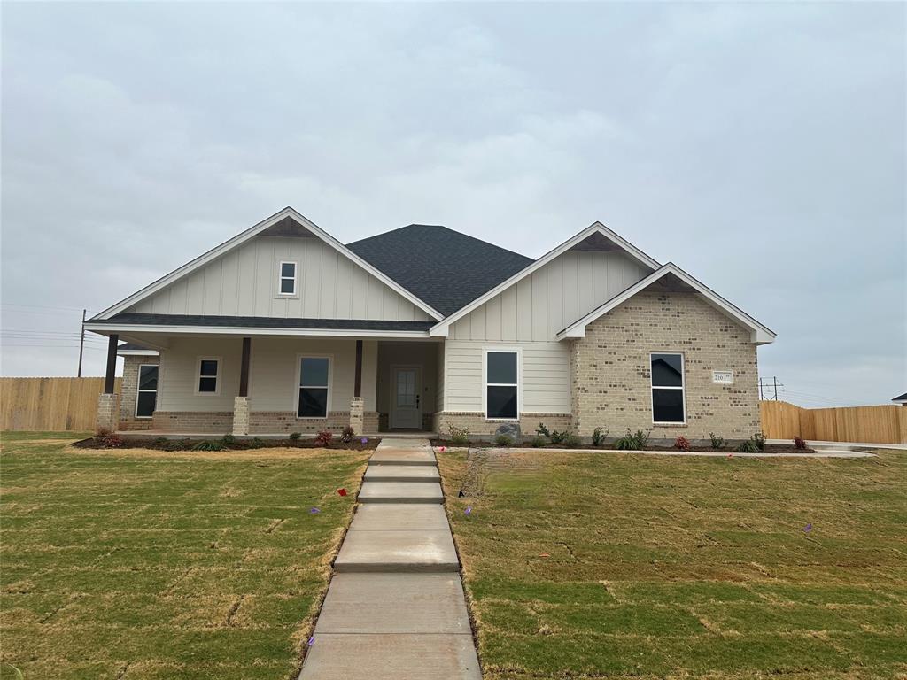 a front view of house with yard and trees in the background