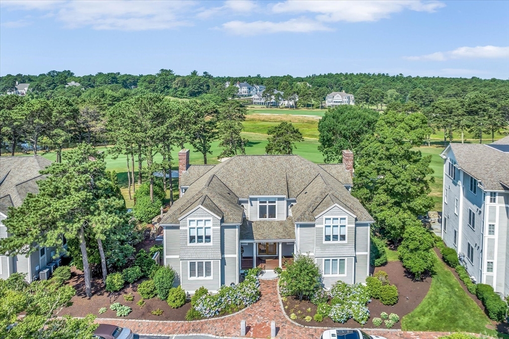 a view of a big house with a big yard plants and large trees