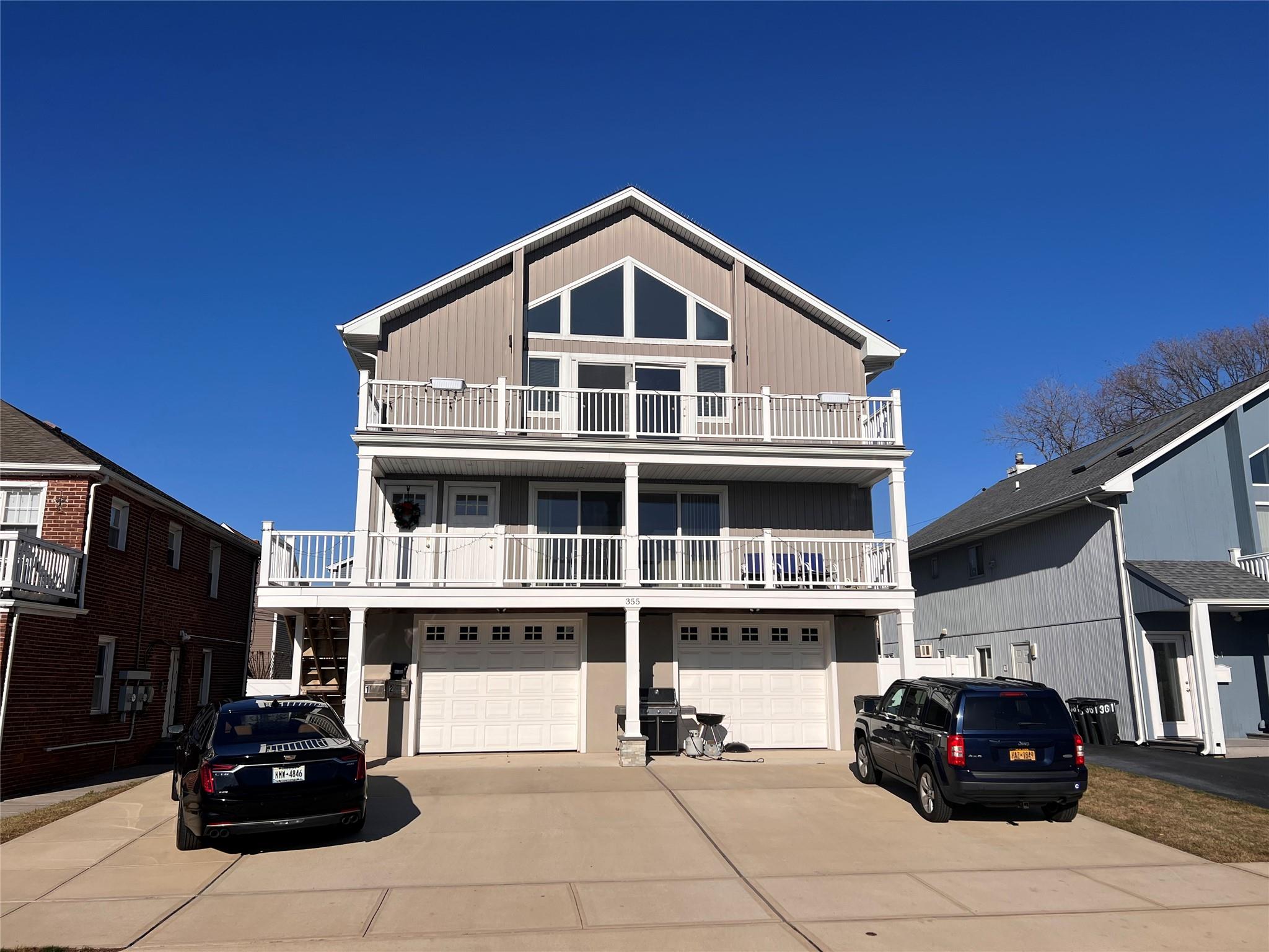 Coastal inspired home featuring a balcony and a garage