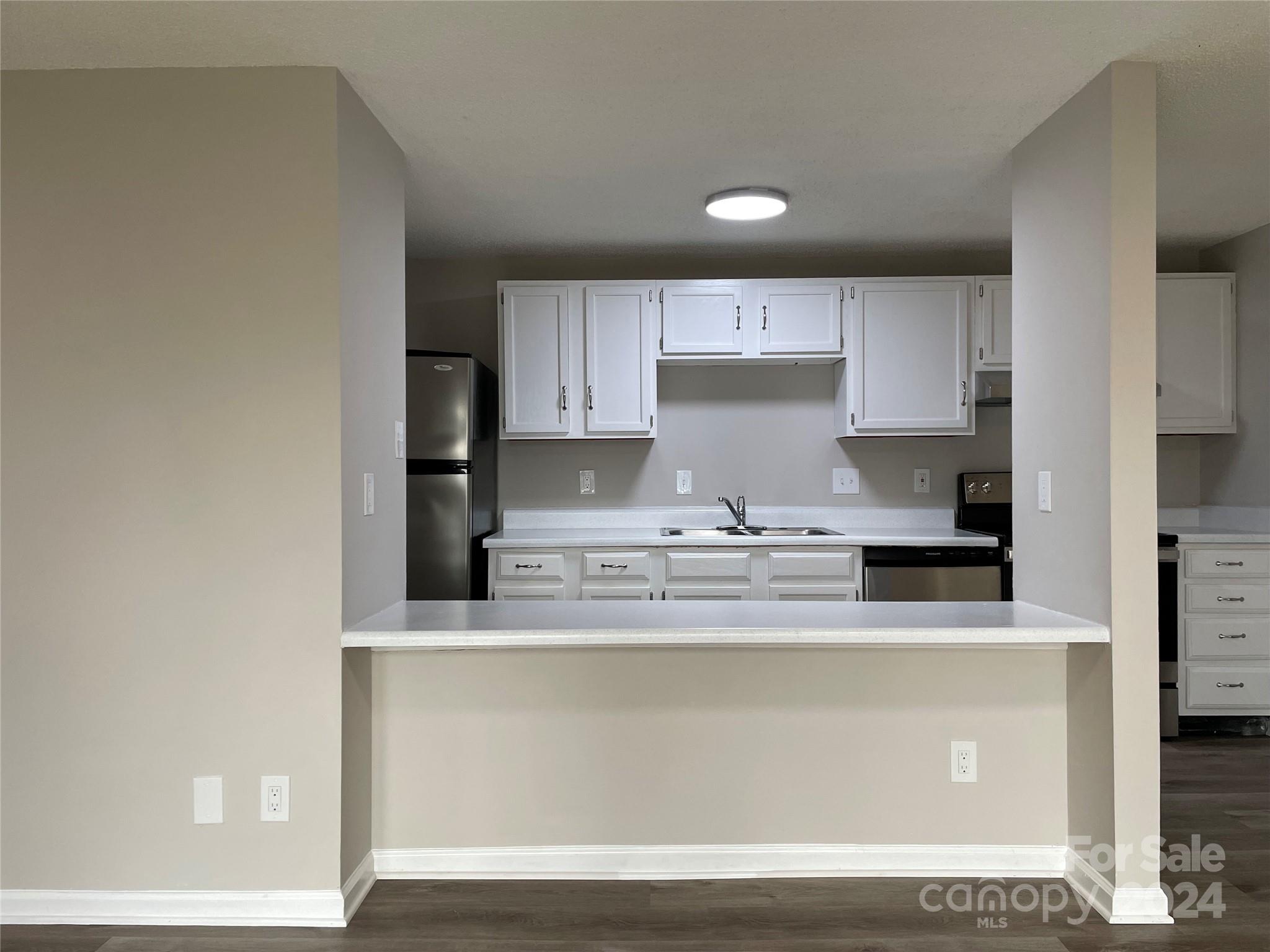 a kitchen with kitchen island sink stove and cabinets