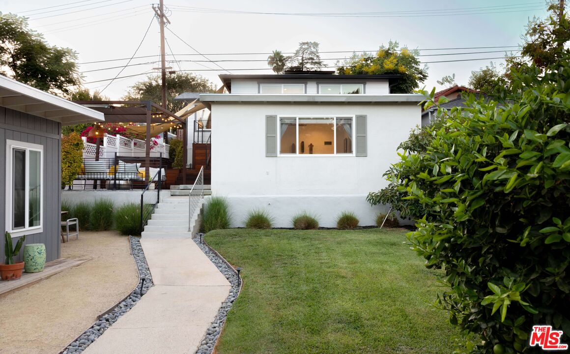 a view of a house with a yard and sitting area