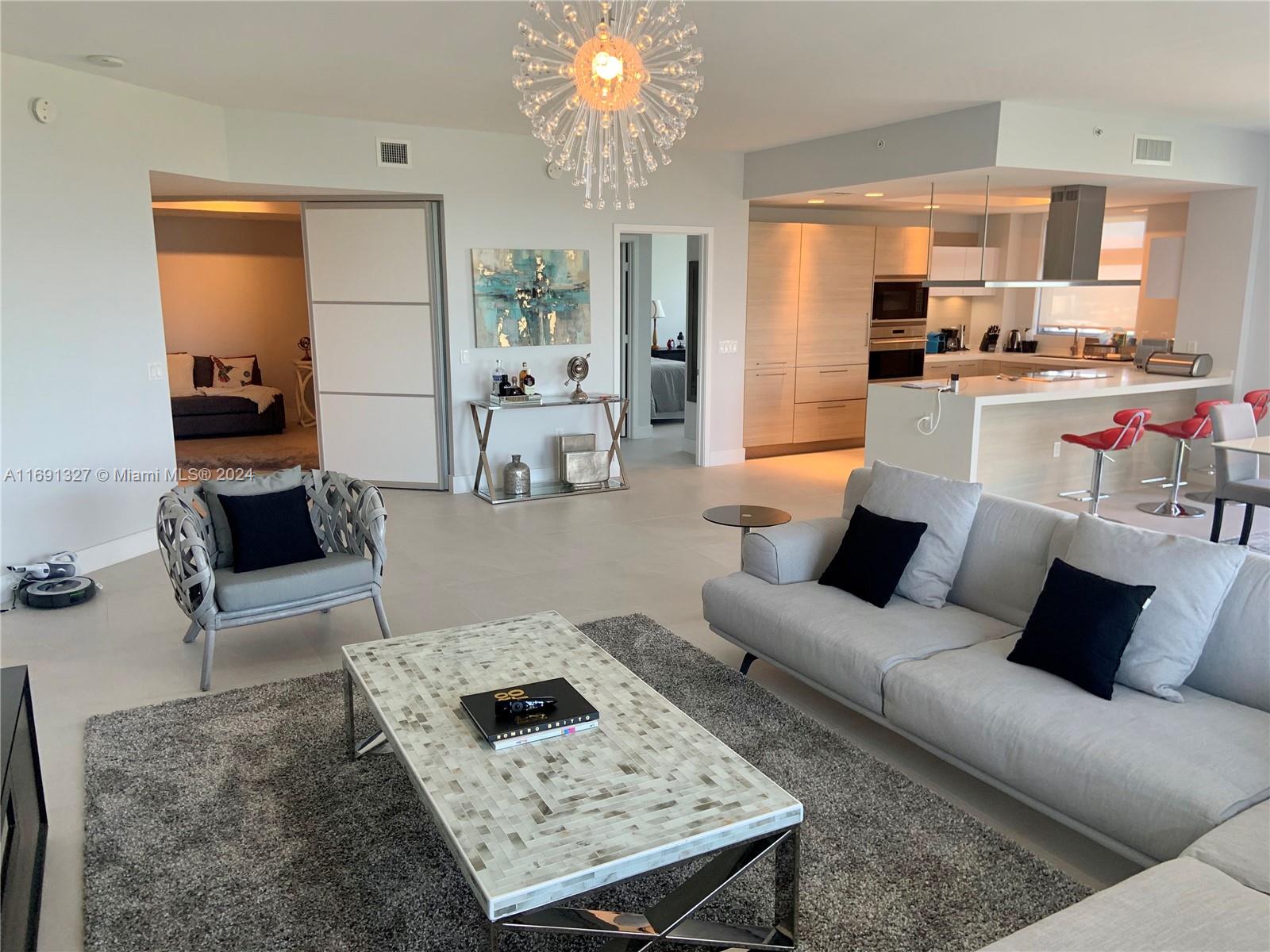 a living room with furniture and a chandelier