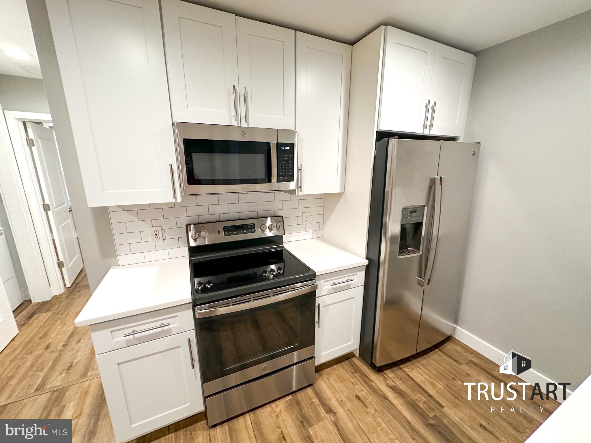 a kitchen with cabinets stainless steel appliances and a counter space