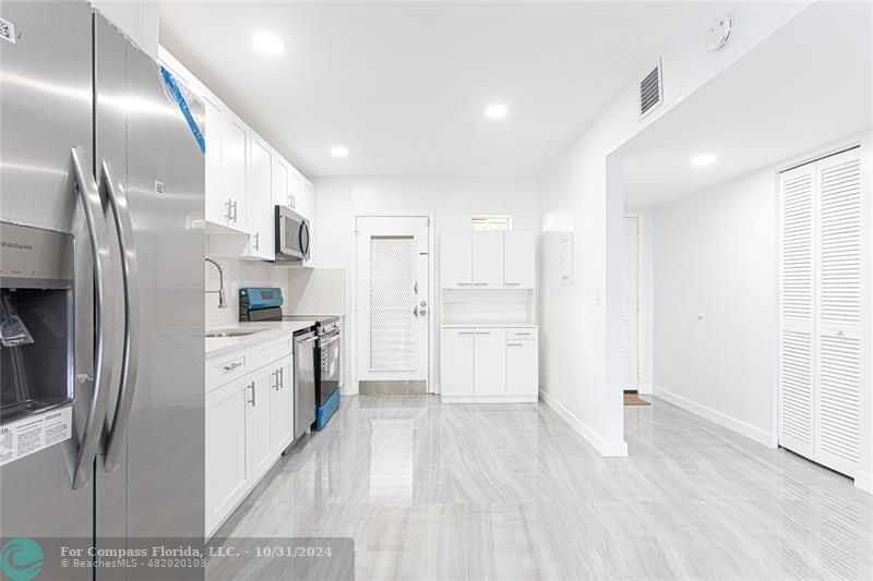 a large kitchen with cabinets and stainless steel appliances