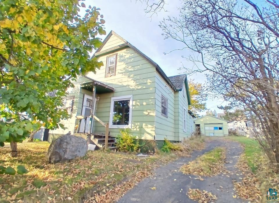 View of front of house with an outbuilding and a garage