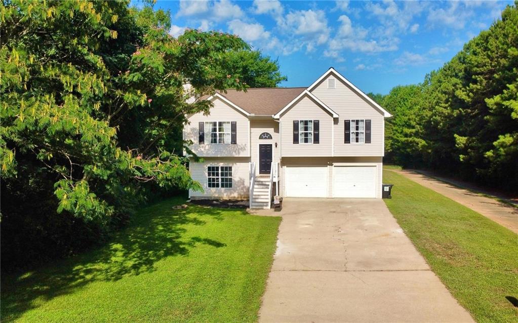 a front view of a house with yard and green space