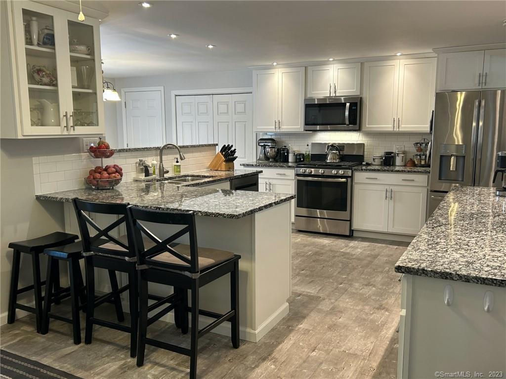 Kitchen with breakfast bar. Granite counters. Stainless steel appliances.