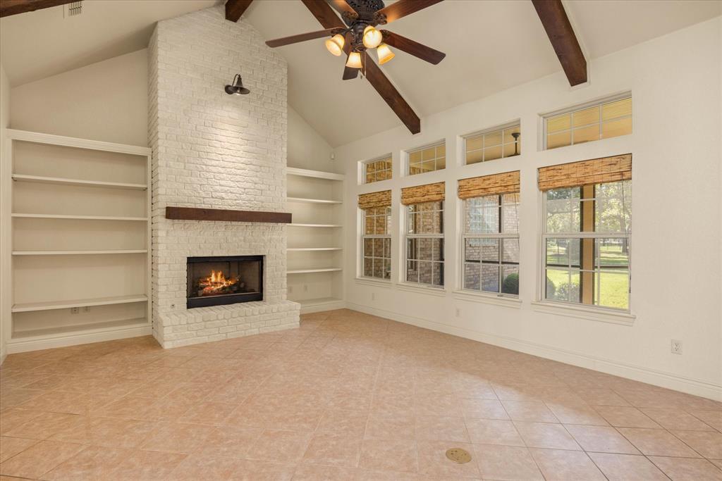 a view of an empty room with a fireplace and a window