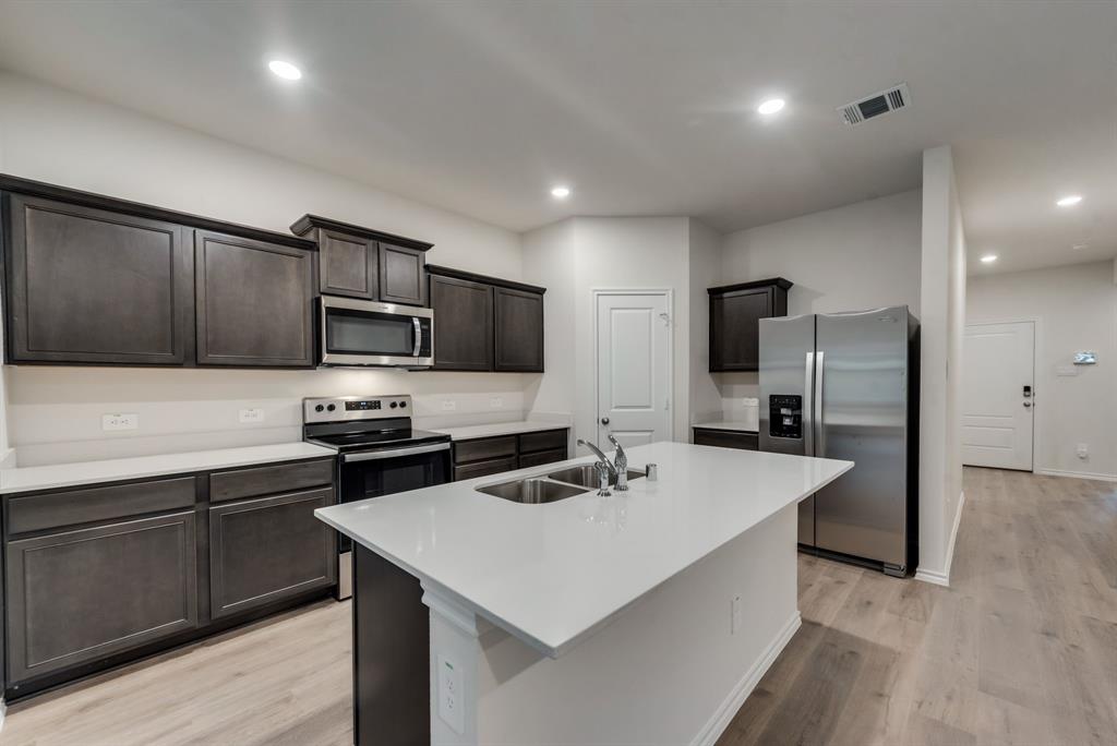 a kitchen with sink a microwave and refrigerator